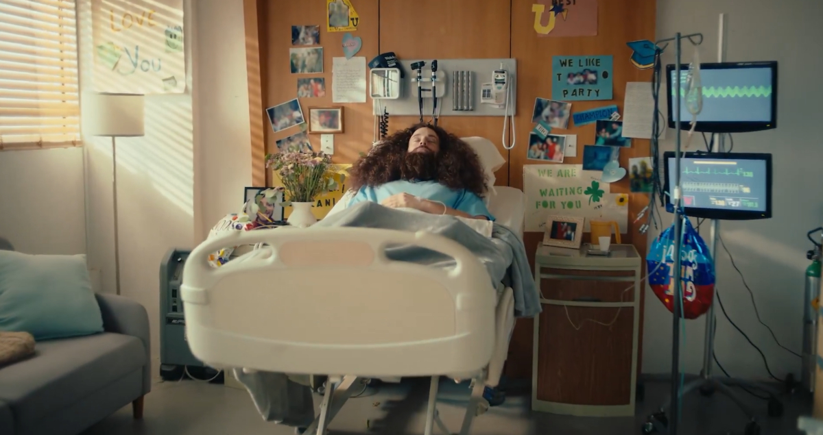 image of a hospital bed with a man laying in it with his eyes closed