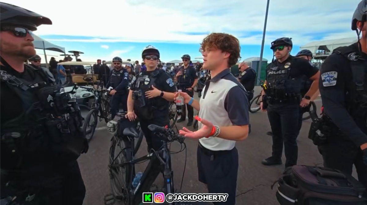 Jack Doherty wearing a Nike Polo standing the middle of Police Officers wearing bike helmets