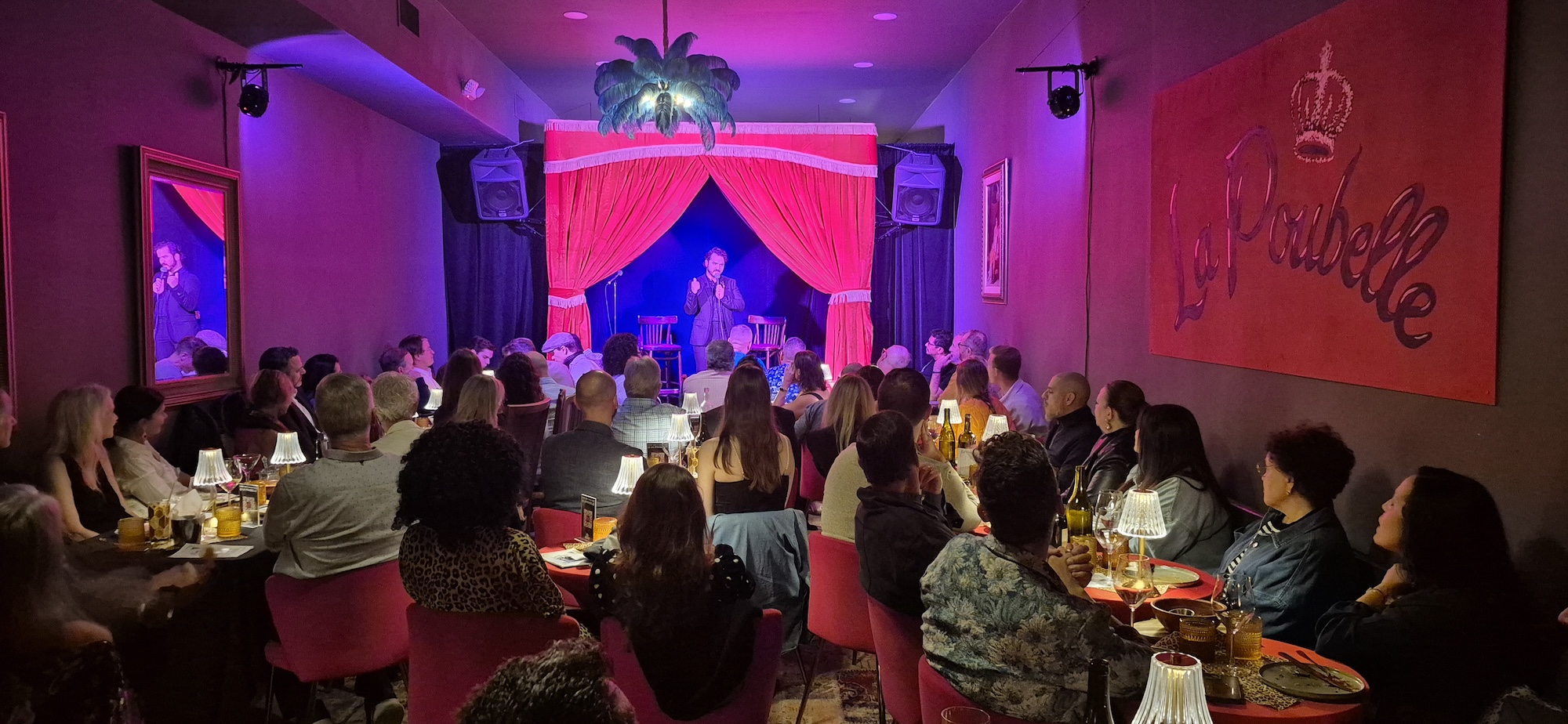 Photo of a small red room with a performer on stage.