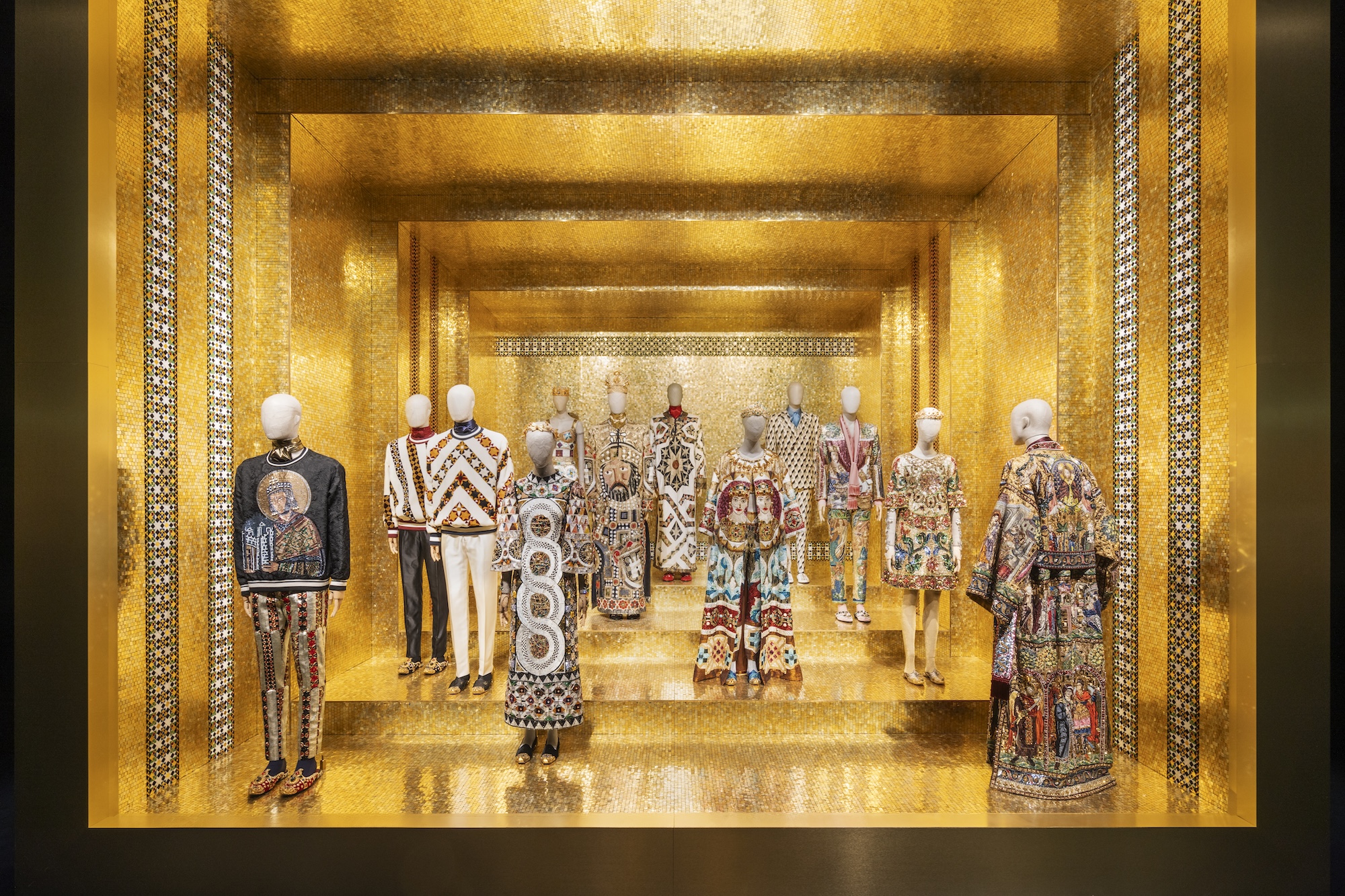 photo of outfits on mannequins inside a room with gold walls and flooring
