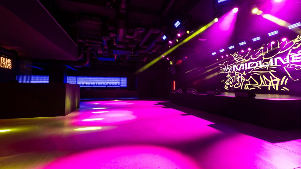 Photo of a stage and a concert room with a screen that reads Midline