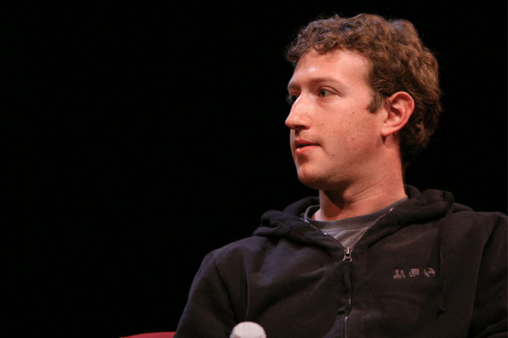 Mark Zuckerberg looks away from the camera while wearing a black half zip