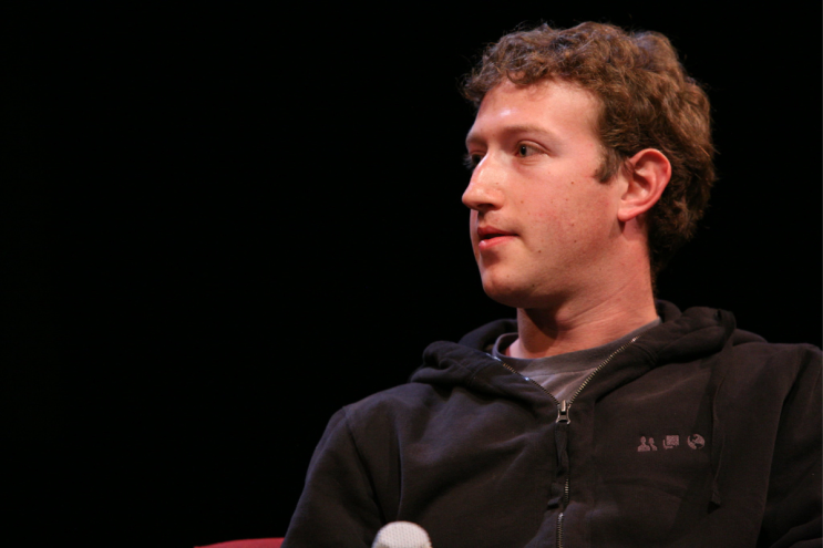 Mark Zuckerberg looks away from the camera while wearing a black half zip
