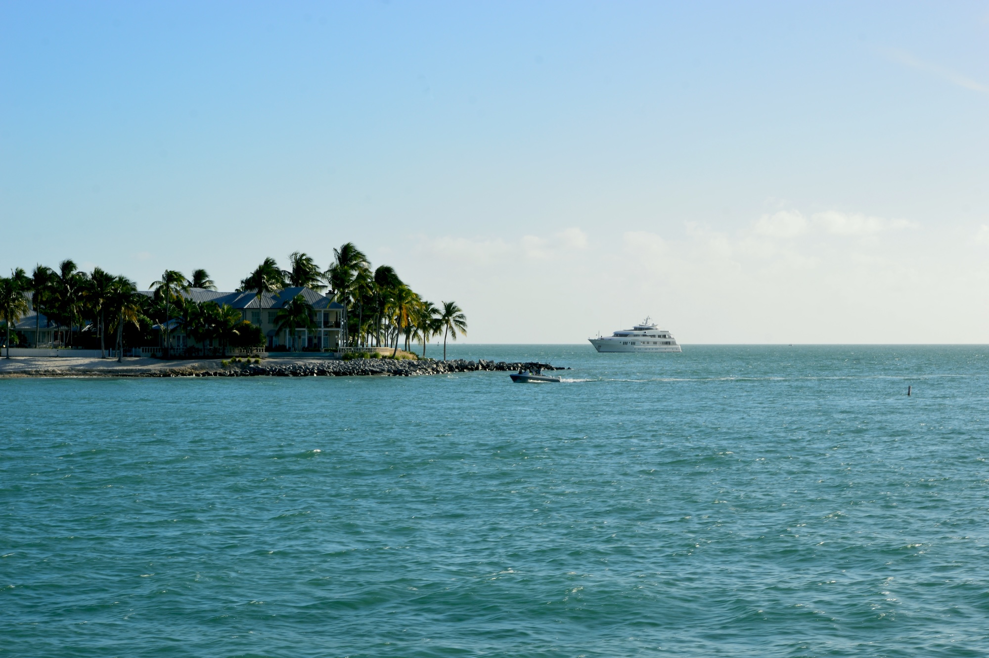 photo of a cruise ship approaching an island surrounded by ocean