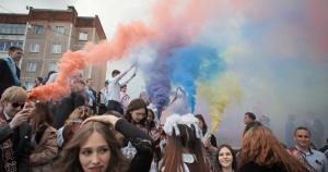 film still from the documentary Mr Nobody Against Putin showing colored smoke flares above a crowd