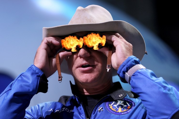 photo of Jeff Bezos in a Blue Origin suit with the reflection of an explosion in his glasses