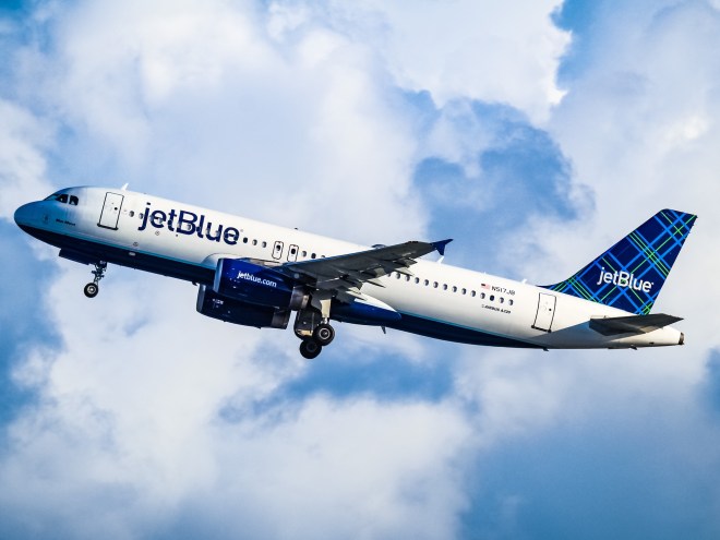 photo of a JetBlue plane flying through the clouds