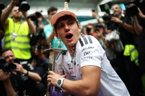 photo of Formula 1 driver Andrea Kimi Antonelli holds a trophy as someone pours champagne on him after the Miami Grand Prix