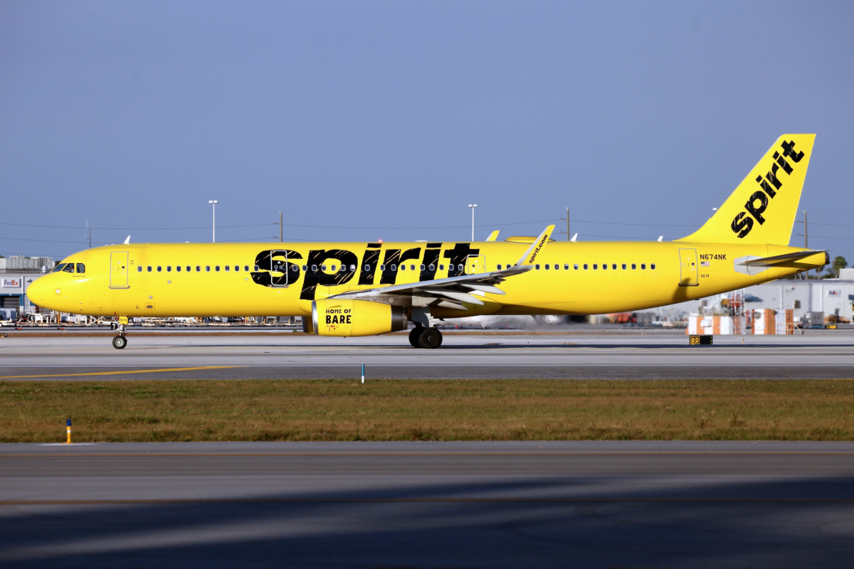 A photo of a bright yellow Spirit Airlines plane landing in Miami.