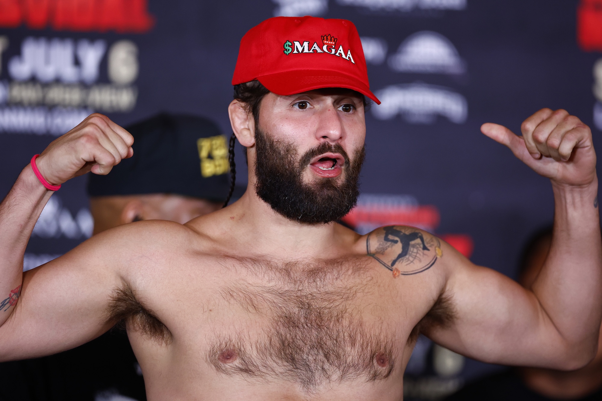 photo of MMA fighter Jorge Masvidal wearing a red MAGA hat and flexing at weigh-in