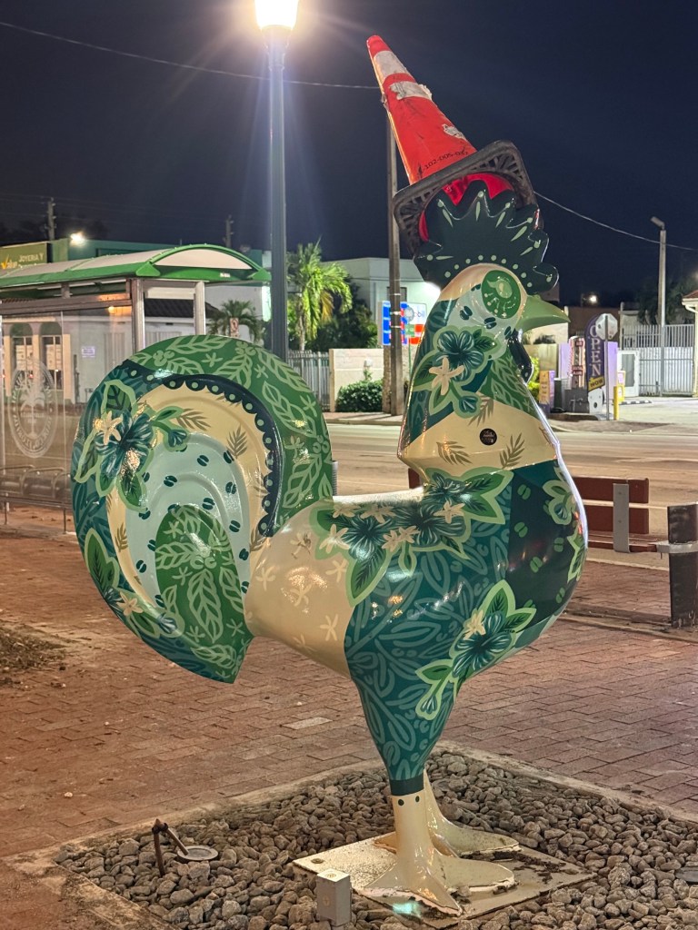photo of a rooster sculpture with a cone on its head