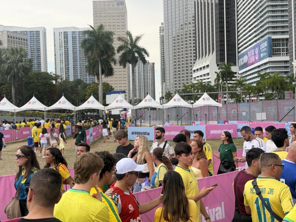 photo of people in line for an outdoor festival queuing around barricades