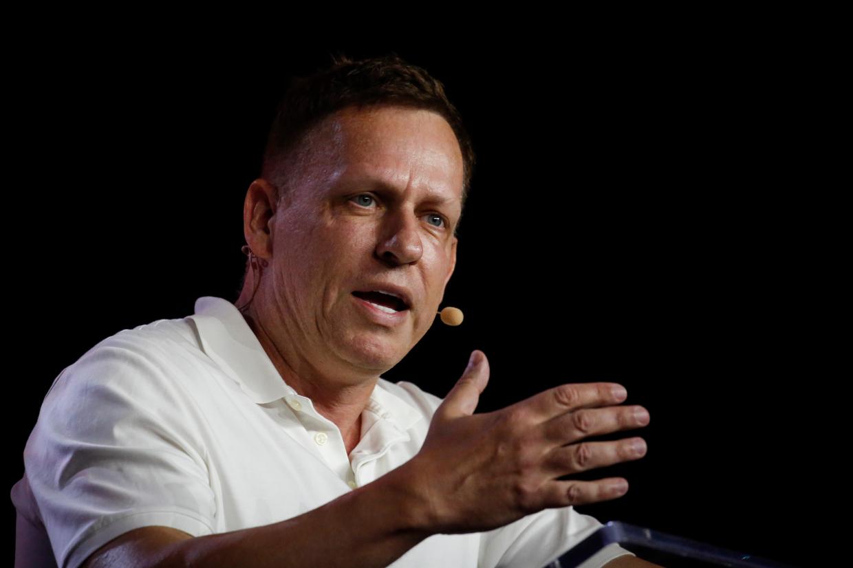 Peter Thiel speaks against a black background while wearing a white collared shirt