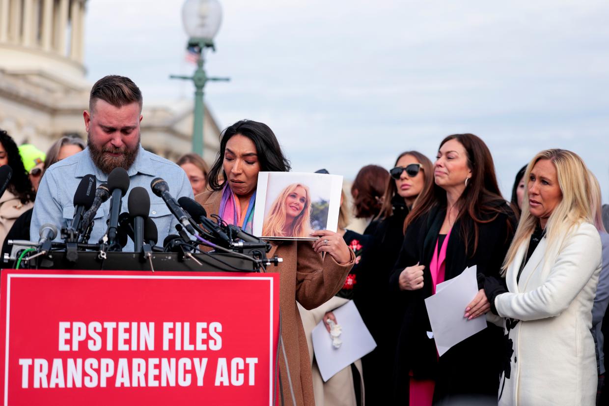 Sky Roberts (L), brother of Virginia Giuffre, who was abused by Jeffrey Epstein, and his wife Amanda Roberts hold up a photo of Giuffre as they speak during a news conference with lawmakers on the Epstein Files Transparency Act outside the U.S. Capitol on November 18, 2025 in Washington, DC.