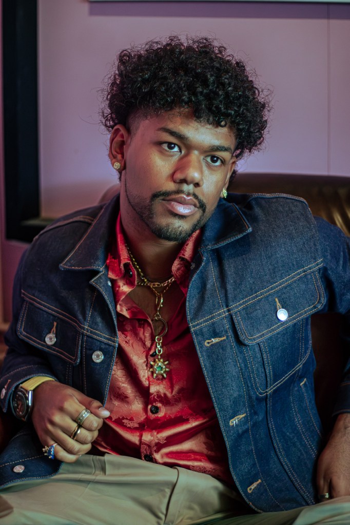 Photo of a young Miami musician posing for the camera wearing a denim jacket.