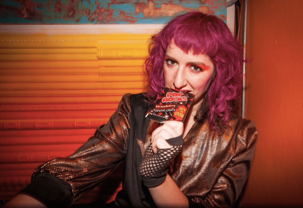 Picture of a woman with purple hair looking at the camera.