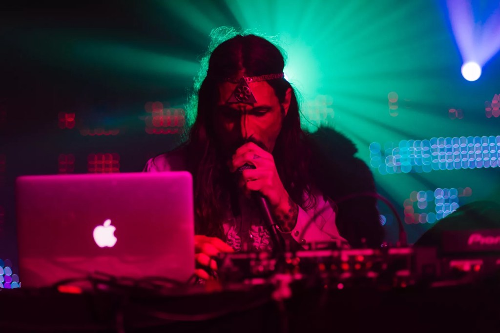Aman singing on a mic in front of a computer .