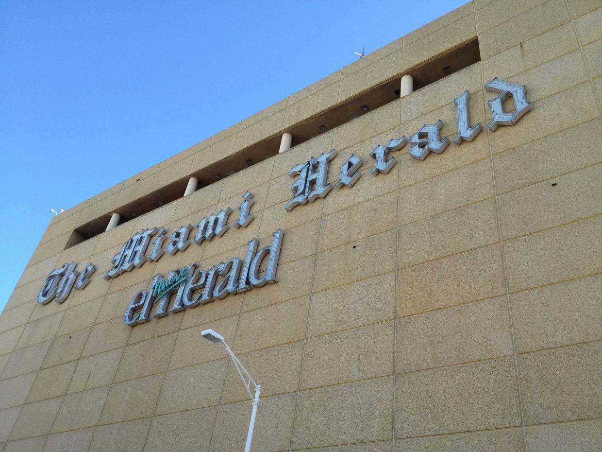 photo of the facade of a building with a sign reading, 'The Miami Herald' and 'El Nuevo Herald'