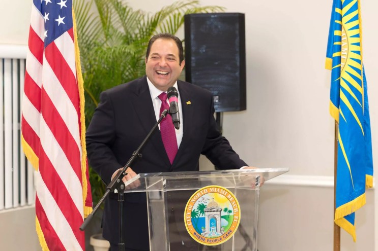 Former North Miami Beach Mayor Anthony DeFillipo smiles from behind a podium.