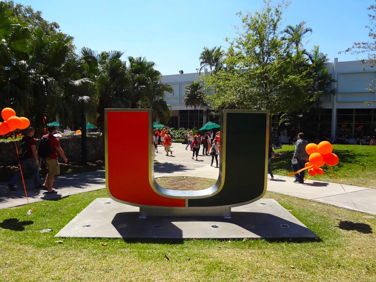 Green and orange University of Miami sign on campus