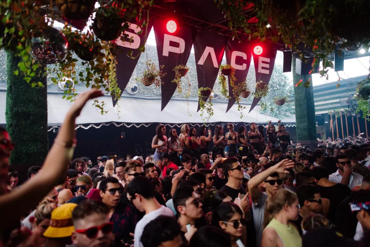 Photo of a group of people dancing at a venue under a sign that reads Space.