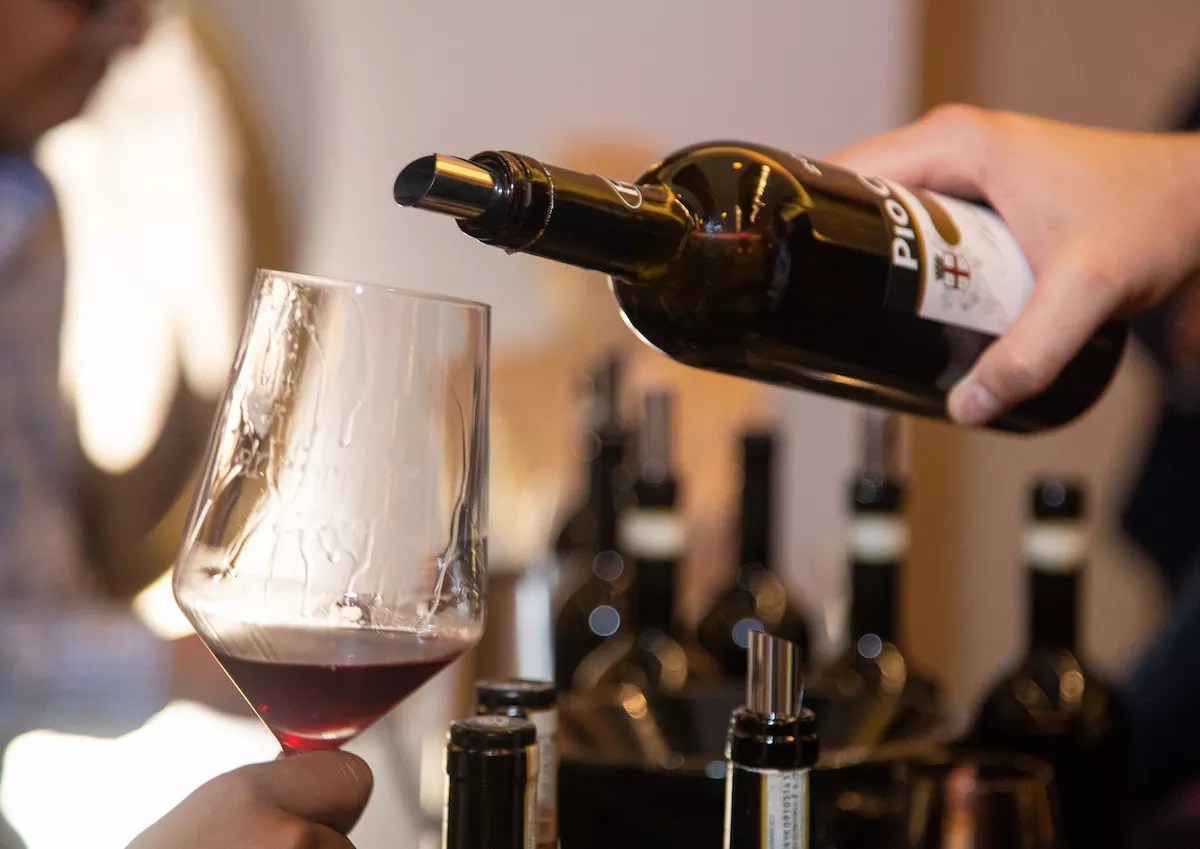 a person pouring a bottle of wine