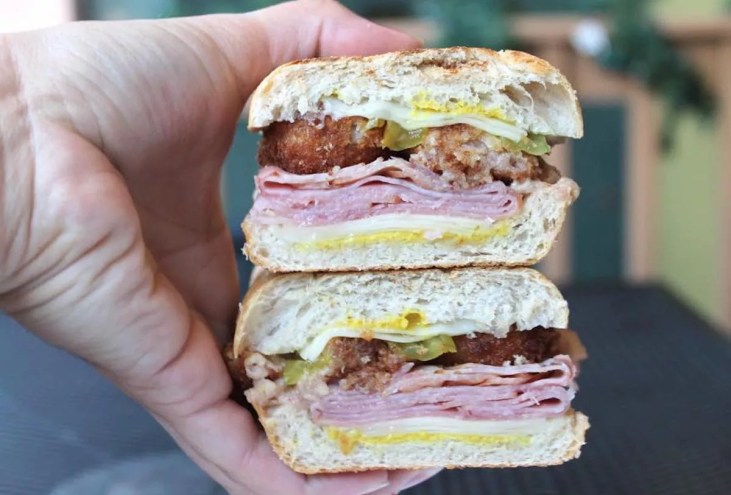 A hand holding a sandwich