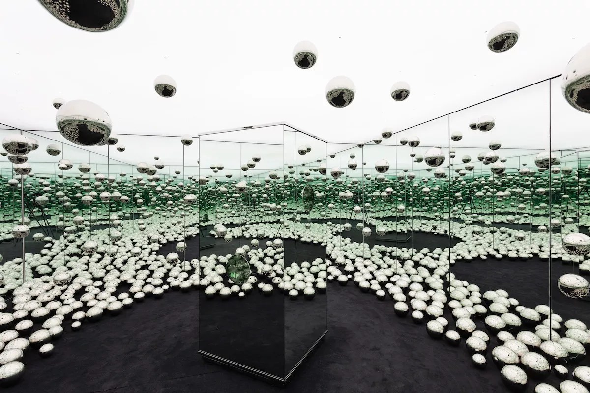photo of a mirrored room filled with chrome balls