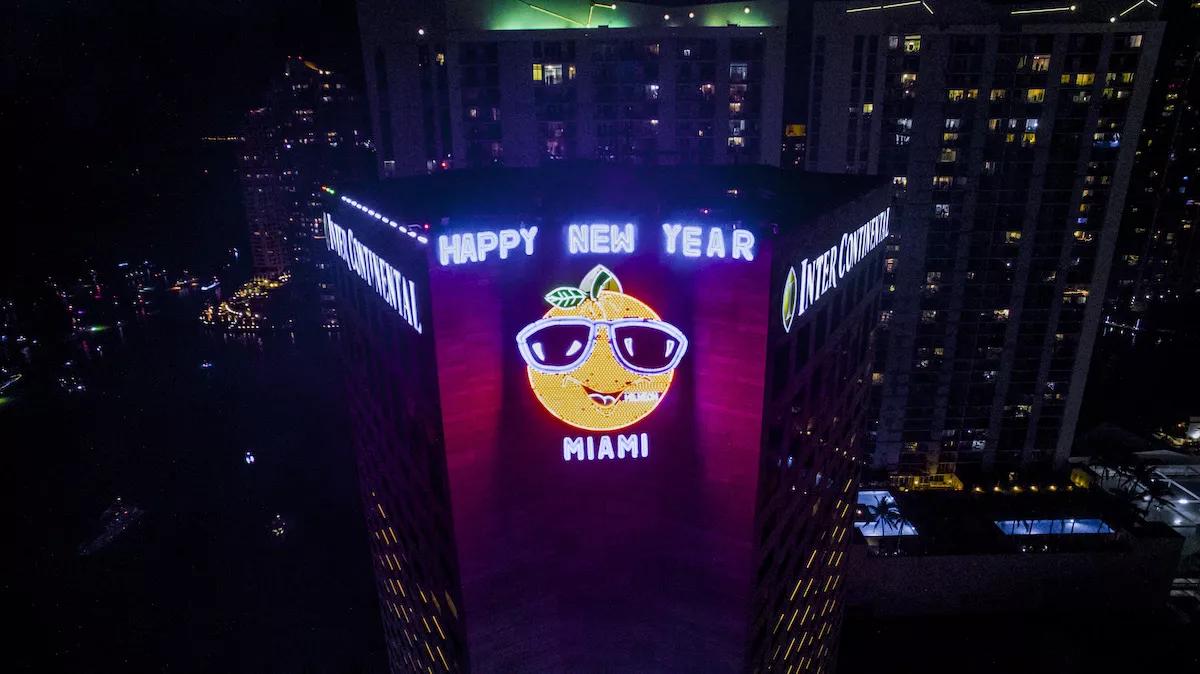 Neon orange caricature on the side of the InterContinental Hotel in Miami