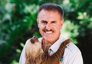 photo of Ron Magill smiling at the camera while holding a sloth