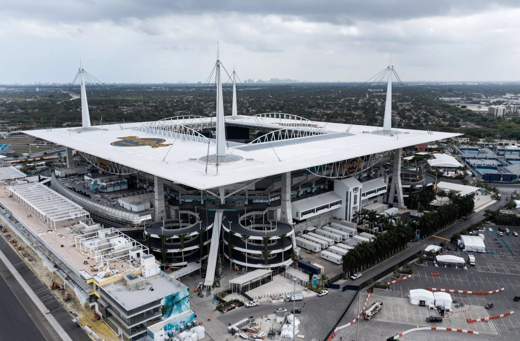 Hard Rock Stadium in Miami Gardens is a modern square building  with a flat, white roof that opens to the sky in the center