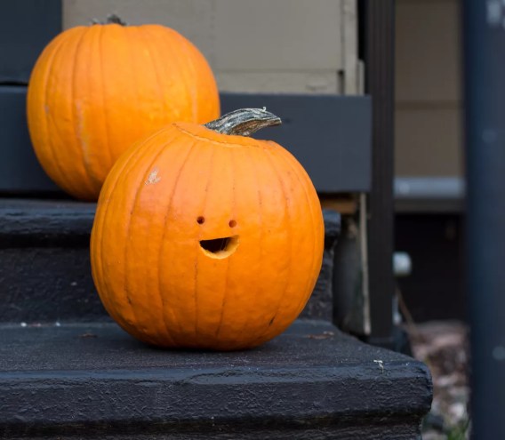 A carved pumpkin smiles from a small stairwell