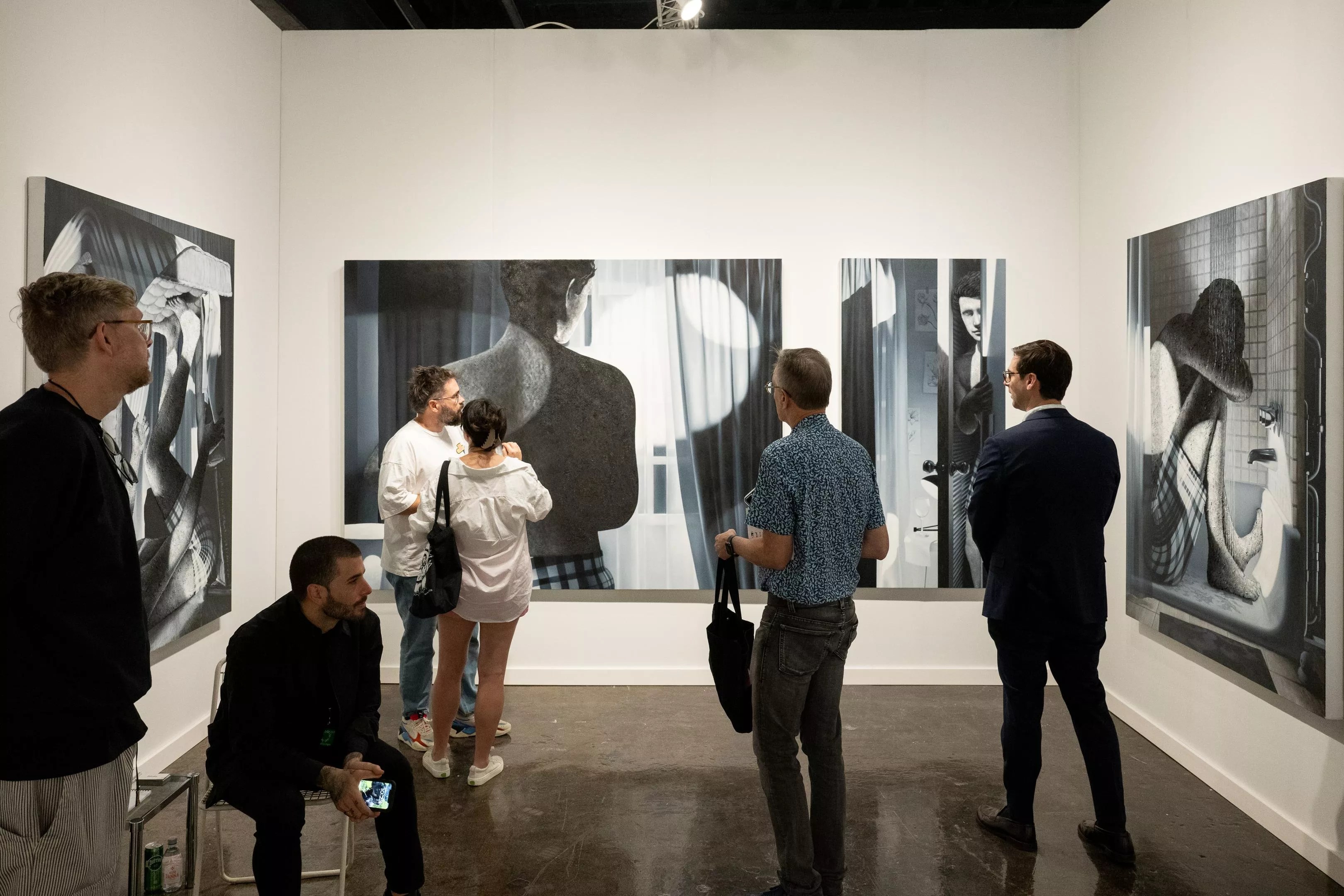People observing the booth of Primary gallery at NADA art fair in Miami