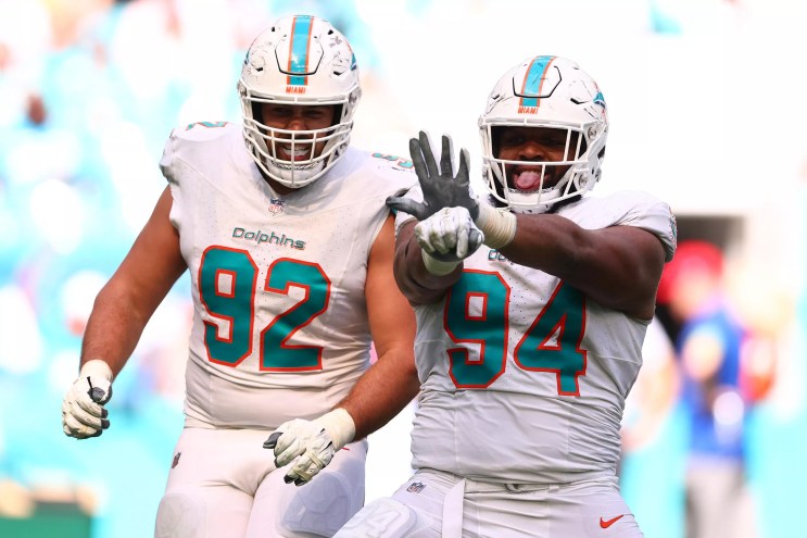 Dolphins players Sieler and Wilkins stand next to one another