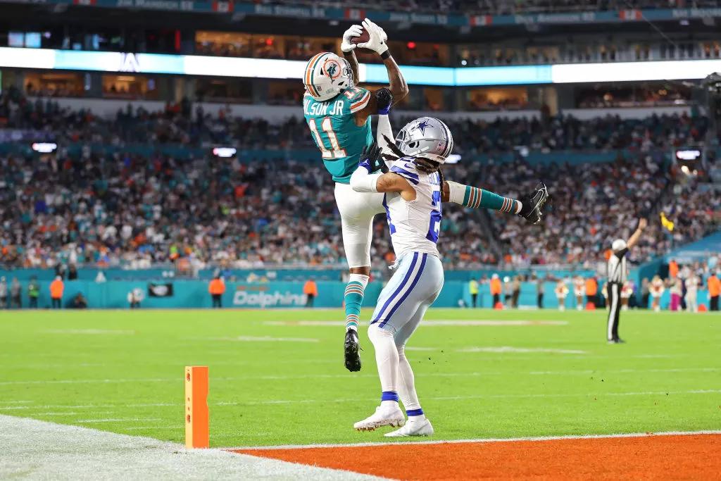 Miami Dolphins player leaps at the edge of the endzone to retrieve a pass