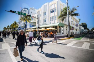 People walking along Ocean Drive in Miami Beach in front of art deco buildings