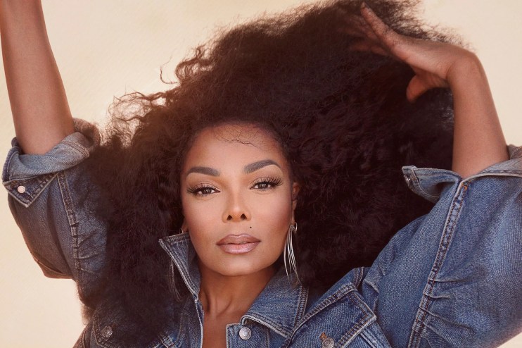 Janet Jackson starring at the camera while brushing her hair with her fingers