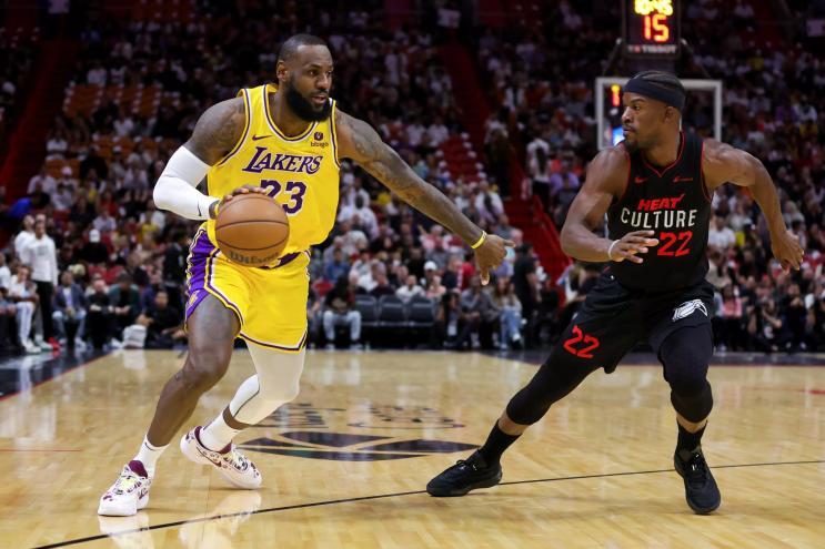 LeBron James looks to fend off Jimmy Butler in a game against the Miami Heat.