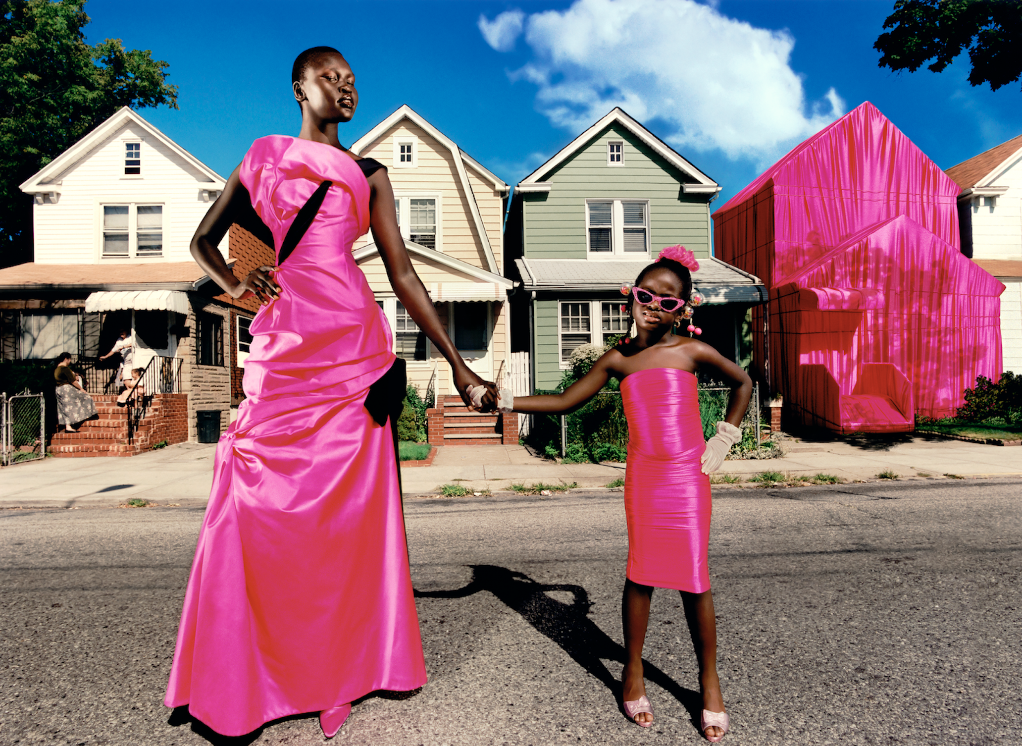 Black woman and child posing on the street in hot-pink dresses