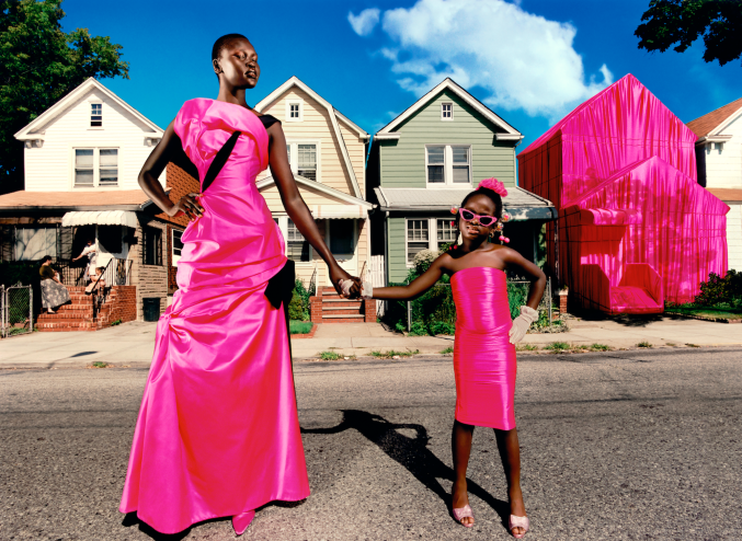 Black woman and child posing on the street in hot-pink dresses