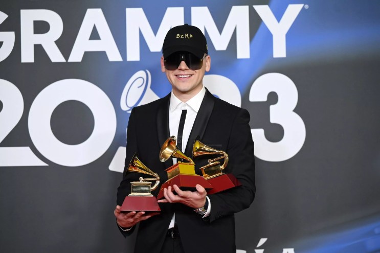Bizarrap posing with three Latin Grammy trophies in his hands