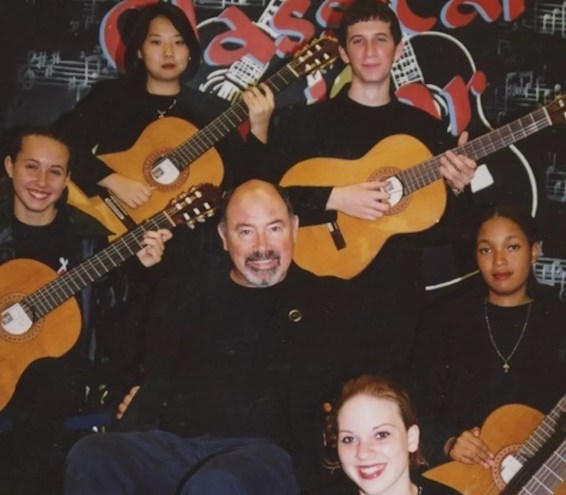 Teacher Doug Burris in a wheelchair surrounded by students