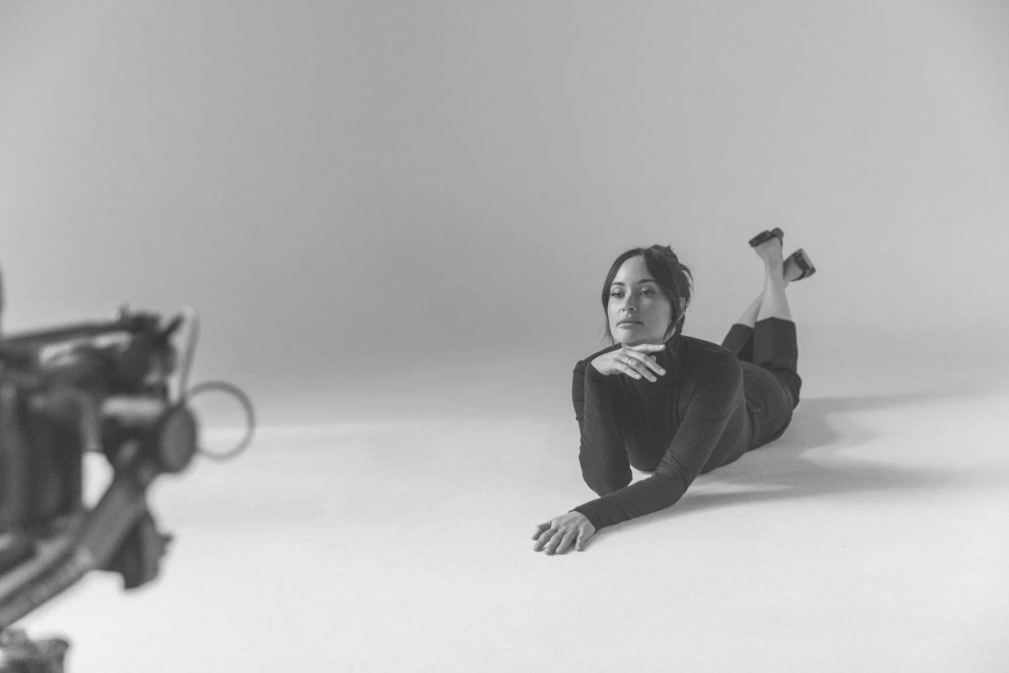 Kacey Musgrave lying on the floor in a black dress