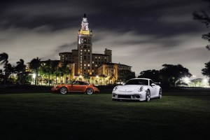Sports cars in the night next to a hotel