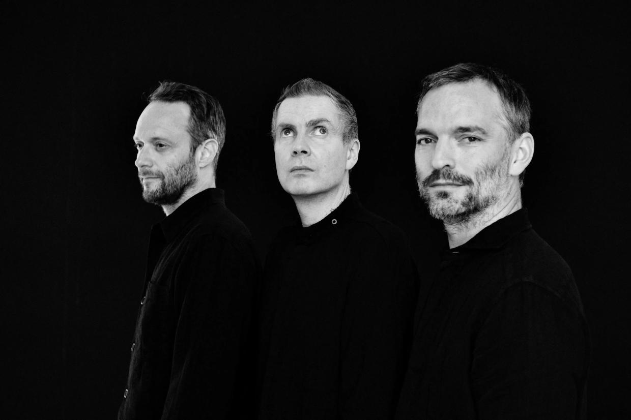 a black and white photo of the three band member's faces