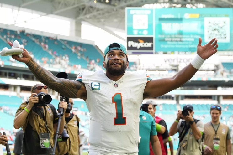 Miami Dolphins quarterback Tua Tagovailoa extends his arms in celebration after a victory in 2023