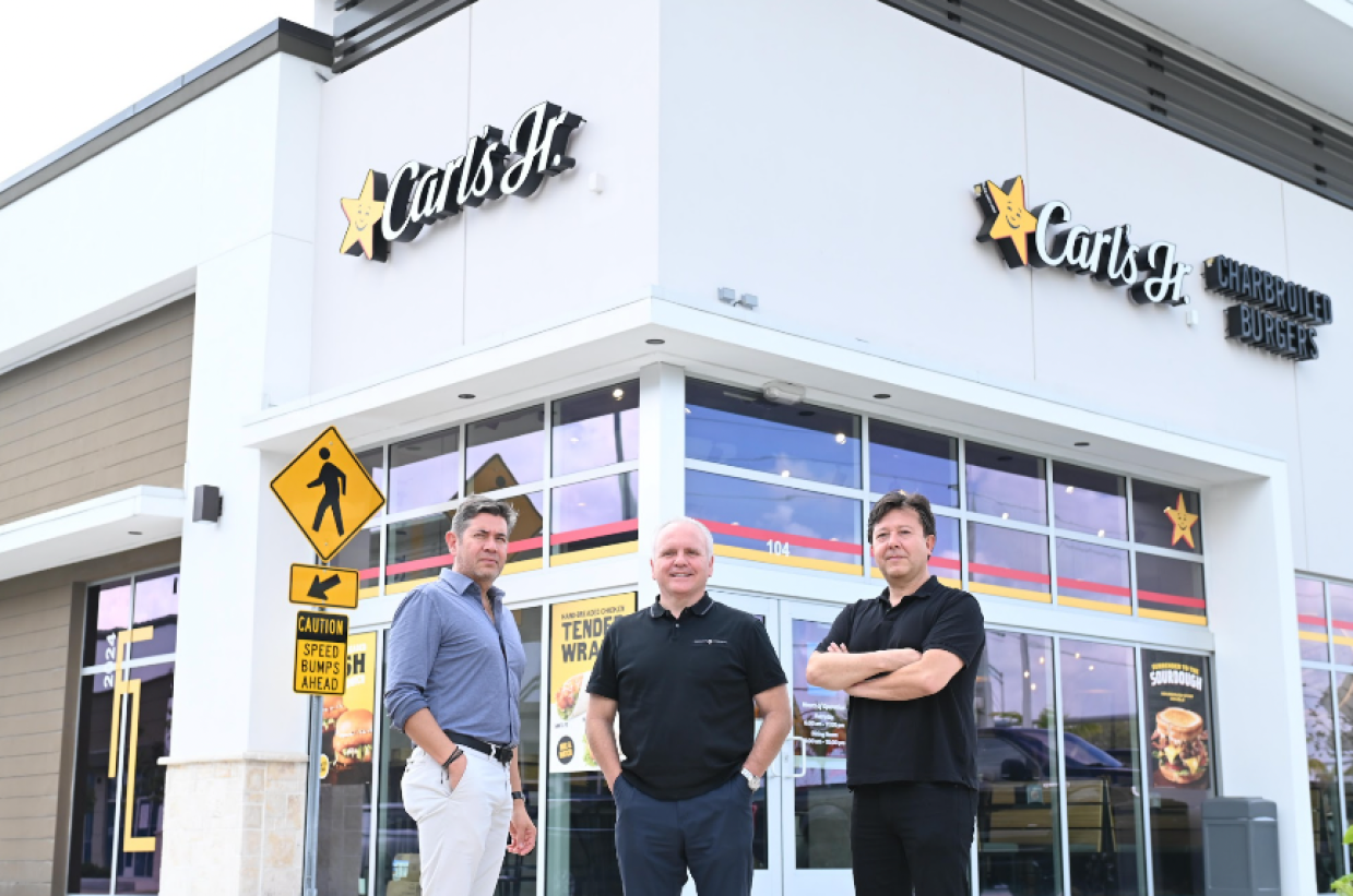 Three men in front of a building