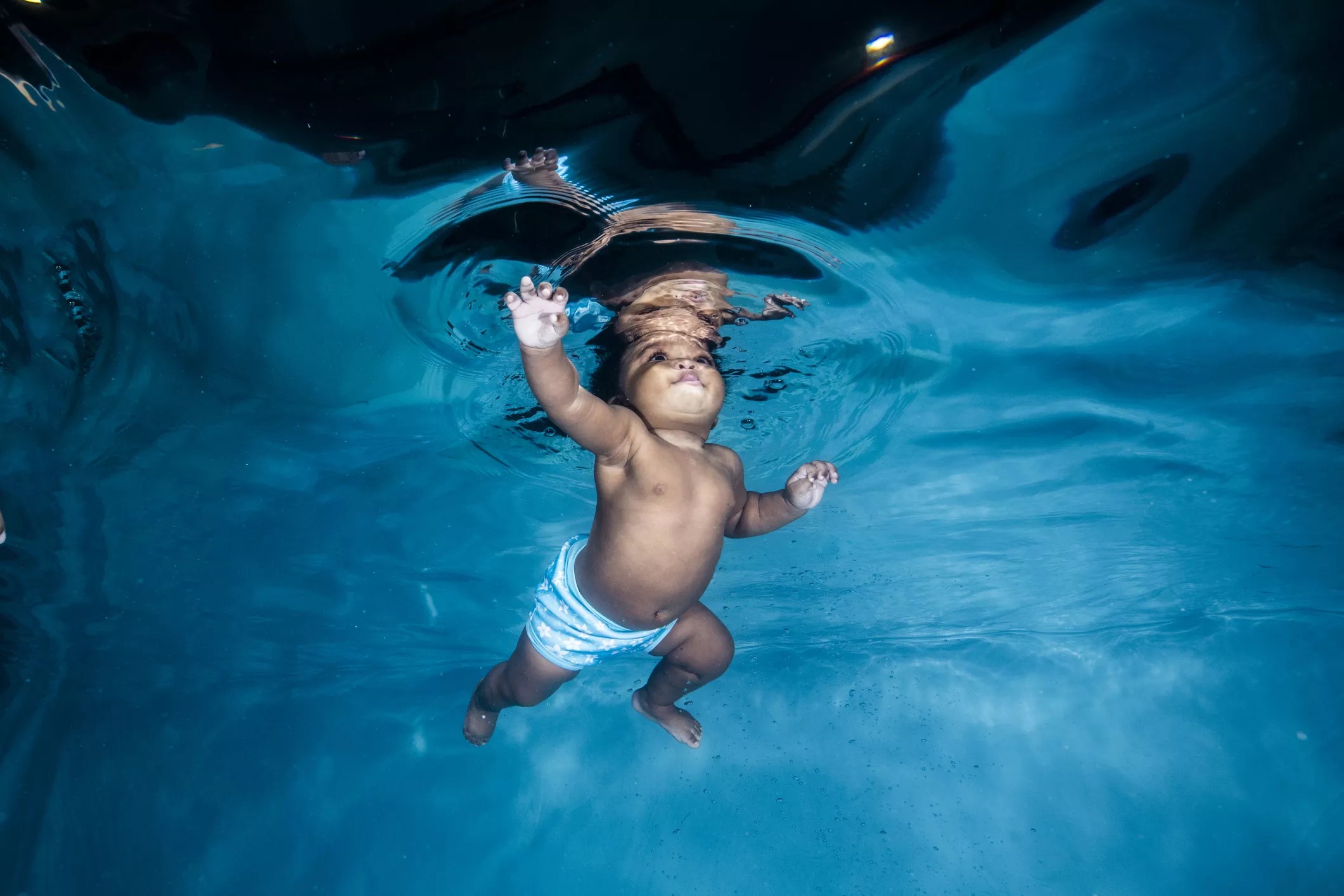 Underwater shot of a toddler swimming in a pool