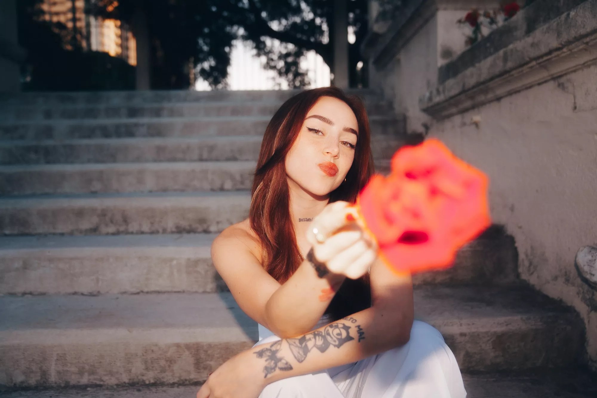 Nicki Nicole holding a flower toward the camera