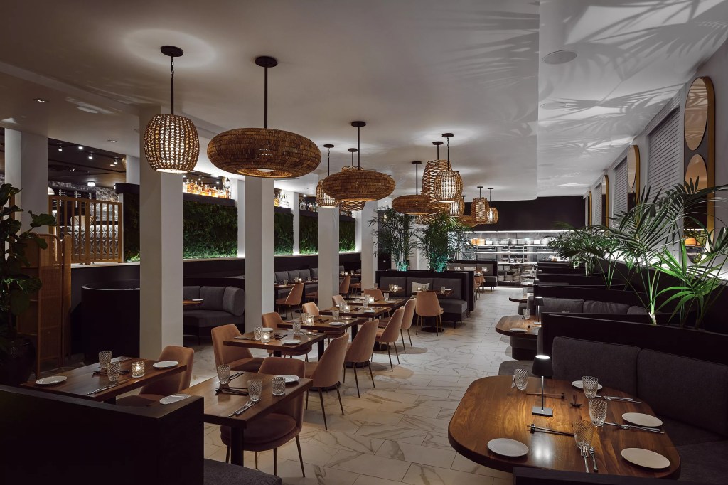 A dining room with rattan chandeliers and white walls